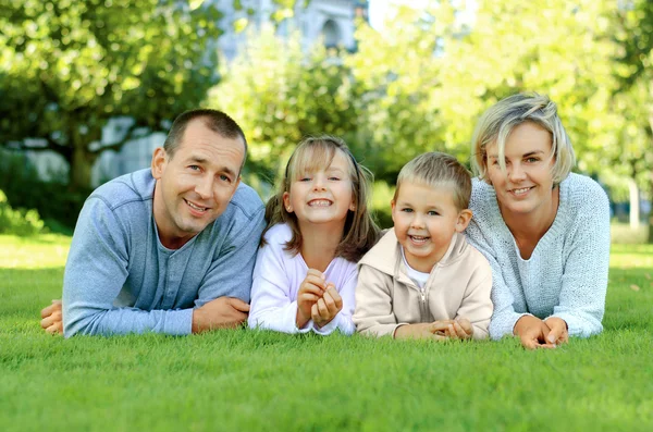 Aile çim üzerinde yalan ve gülümseyen