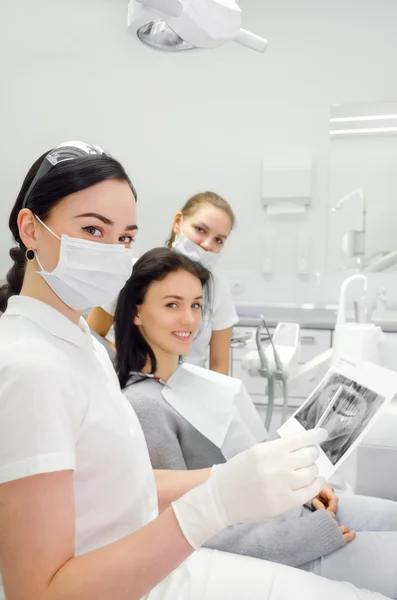 Dentysta i jego asystent wskazują, że pacjent rentgenowskie — Zdjęcie stockowe