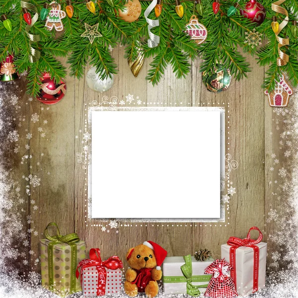 Fondo de felicitación de Navidad con tarjeta, regalos, ramas de pino y adornos de Navidad en el fondo de madera — Foto de Stock