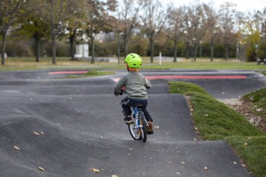 Dışarıda, soğukta bisiklet süren yakışıklı küçük çocuk.