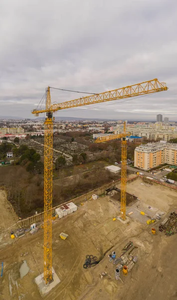 Drone shot of a crane working on a construction site daytime