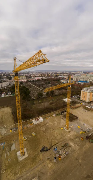 Drone shot of a crane working on a construction site daytime