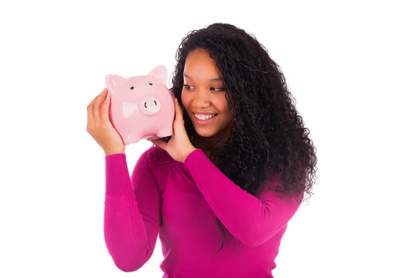 Young african american woman putting coin in piggy bank — Stock Photo, Image