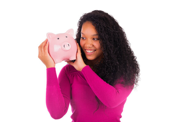 Young african american woman putting coin in piggy bank