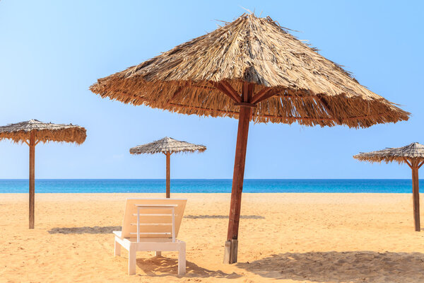 Tropical beach scenery with parasol and deck chairs in Boavista,