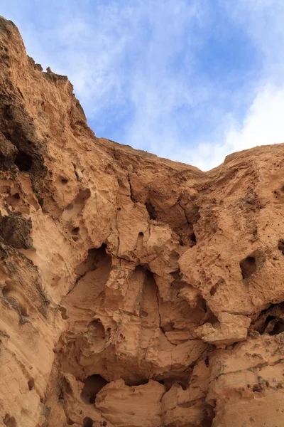 Una parete di roccia contro un cielo blu — Foto Stock