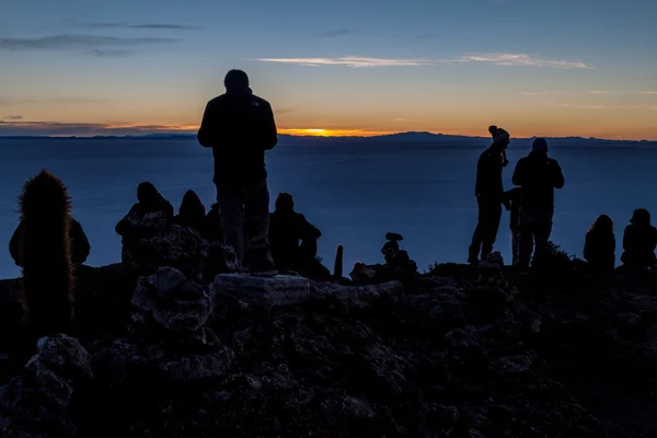 Turistit katsella auringonnousua Isla Incahuasi — kuvapankkivalokuva