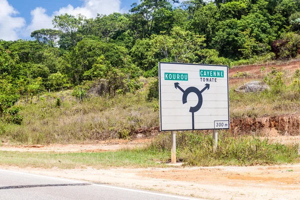 カイエンとフランス領ギアナ クールーを指しているラウンド アバウト交差点で道路標識 — ストック写真