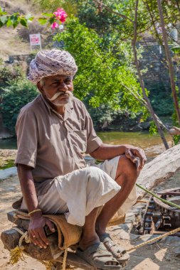 RANAKPUR, Hindistan - 13 Şubat 2017: Yerel adam Rajasthan Eyaleti, Hindistan 'da zincir pompasında çalışıyor