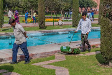 AGRA, Hindistan - 19 Şubat 2017: İşçiler Hindistan 'ın Agra kentindeki Taj Mahal kompleksinde çim biçiyor