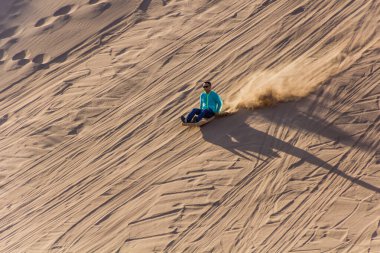 DUNHUANG, Çin - 21 Ağustos 2018: Dunhuang, Gansu Eyaleti yakınlarındaki Singing Sands Dune 'da kum kayağı