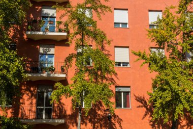 İtalya, Bologna 'da ağaçlar ve kırmızı bir bina
