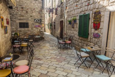 KOTOR, MONTENEGRO - 1 Haziran 2019: Karadağ 'ın Eski Kotor kentindeki dar bir sokakta açık hava restoranı.