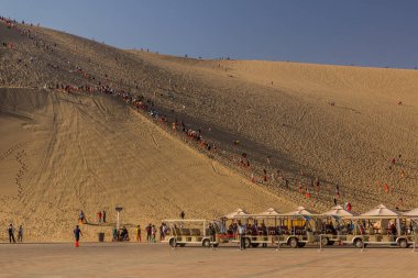 DUNHUANG, Çin - 21 Ağustos 2018: Turistler Dunhuang, Gansu Eyaleti, Çin yakınlarındaki Şarkı Söyleyen Kumlar Dune 'a tırmanıyor