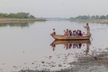 AGRA, Hindistan - 19 Şubat 2017: Hindistan 'ın Agra kentinde Taj Mahal' i izleyen Yamuna Nehri 'ndeki bir teknede turistler