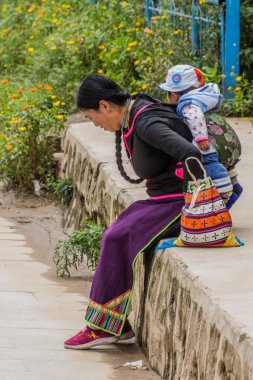 XIAHE, ÇİN - 25 AĞUSTOS 2018: Tibetli bir kadın bebeğiyle birlikte Xiahe kasabasında, Gansu, Çin