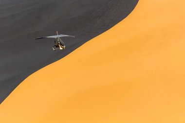 Rogalo, Çin 'in Gansu Eyaleti, Dunhuang yakınlarındaki Singing Sands Dune üzerinde uçuyor.