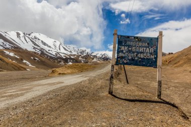PAMIR HIGHWAY, TAJIKISTAN - MAY 27, 2018: Sign Ak Baital pass at Pamir Highway in Gorno-Badakhshan Autonomous Region, Tajikistan clipart