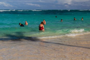 PUNTA CANA, DOMINICAN Cumhuriyet - 8 ARALIK 2018: İnsanlar Dominik Cumhuriyeti 'nin Bavaro plajında suyun keyfini çıkarıyor
