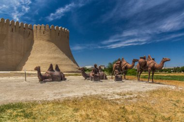 TÜRKİSTAN, KAZAKHSTAN - 31 Mayıs 2018: Deve kervanı heykeli ve Türkistan, Kazakistan 'daki eski duvarlar
