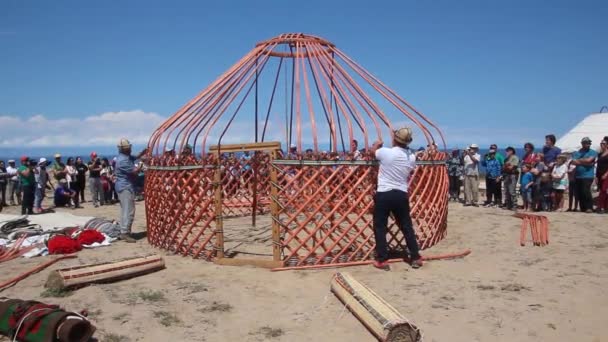 ISSYK KUL, KYRGYZSTAN - 15 LUGLIO 2018: La gente del posto costruisce una yurta all'Ethnofestival Teskey Jeek sulla costa del lago Issyk Kul in Kirghizistan — Video Stock