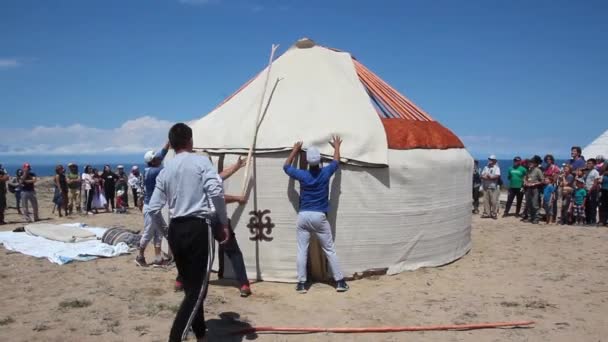 ISSYK KUL, KYRGYZSTAN - 2018年7月15日:キルギスタンのイシク・クル湖沿岸にあるエスノフェスティバル・テスキー・ユダヤでユルトを作る地元の人々 — ストック動画