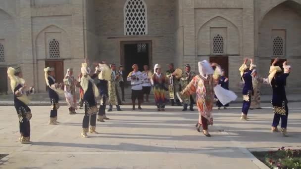 BUKHARA, UZBEKISTÁN - 30 DE ABRIL DE 2018: Bailarinas con vestimenta tradicional en el centro de Bujará, Uzbekistán — Vídeo de stock