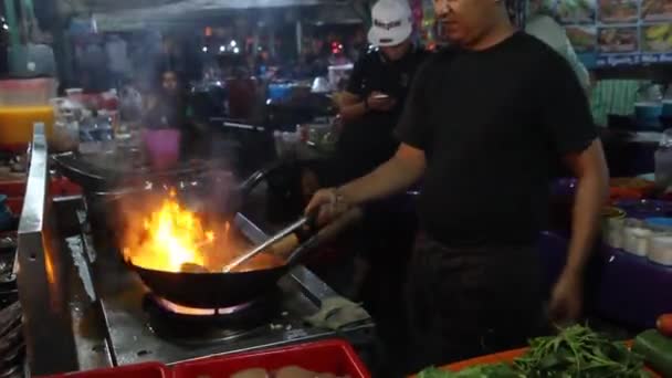 KOTA KINABALU, MALAYSIA - FEBRUARY 24, 2018: 말레이시아 사바의 코타키나발루의 야간 시장에서 프라이팬을 하는 요리사 — 비디오