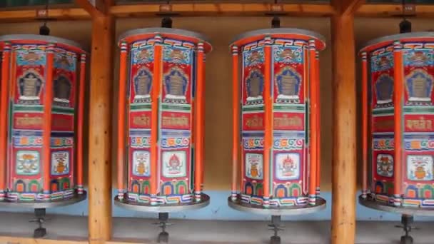 Fila de ruedas de oración alrededor del monasterio de Labrang en la ciudad de Xiahe, provincia de Gansu, China — Vídeos de Stock