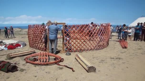 ISSYK KUL, KYRGYZSTAN - 15 DE JULIO DE 2018: Gente local construyendo una yurta en el Ethnofestival Teskey Jeek en la costa del lago Issyk Kul en Kirguistán — Vídeos de Stock