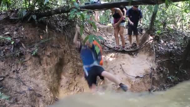 TAMAN NEGARA, MALASIA - 16 DE MARZO DE 2018: Los turistas están cruzando un arroyo en la selva del parque nacional Taman Negara — Vídeos de Stock