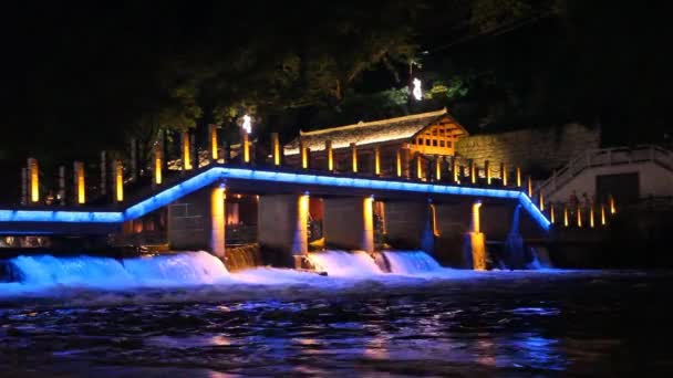 Vista nocturna de un puente y vertedero en Fenghuang Ancient Town, provincia de Hunan, China — Vídeos de Stock