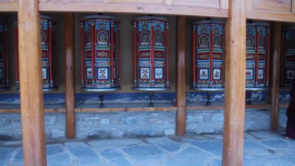 XIAHE, ÇİN - 24 AĞUSTOS 2018: İnsanlar Çin 'in Gansu ilindeki Xiahe kasabasındaki Labrang Manastırı' nda bir sıra dua tekerleği geçiriyorlar — Stok video