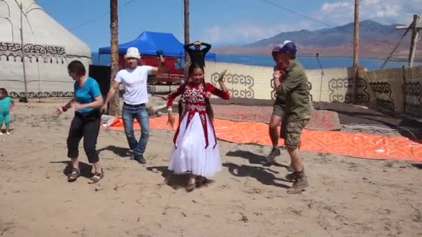 ISSYK KUL, KYRGYZSTAN - 15 juli 2018: Människor dansar på Etnofestivalen Teskey Jeek vid kusten av Issyk Kul sjön i Kirgizistan — Stockvideo