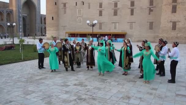 BUKHARA, UZBEKISTAN - APRIL 30, 2018: Dansers en muzikanten in traditionele kleding in het centrum van Bukhara, Oezbekistan — Stockvideo