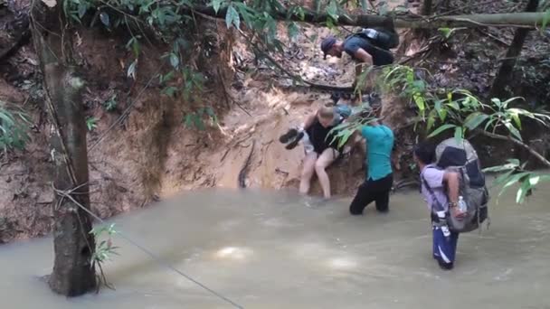 TAMAN NEGARA, MALASIA - 16 DE MARZO DE 2018: Los turistas están cruzando un arroyo en la selva del parque nacional Taman Negara — Vídeos de Stock