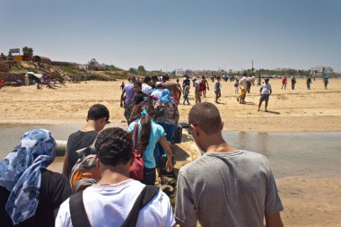 İnsanlar Asilah bir plajda yürüyüş