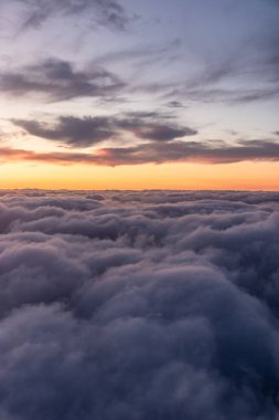 Bulutların üzerinde gün batımını izle