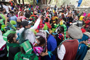 BIRIR, PAKISTAN - 15 Ekim 2023: Kalaşlar geleneksel kostümler giyip Birir Vadisi, Hayber Pakhtunkhwa, Pakistan 'da düzenlenen Phool sonbahar festivalinde dans ediyorlar