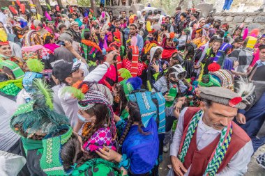BIRIR, PAKISTAN - OCTOBER 15, 2023: Kalash people wearing traditional costumes and dancing at Phool autumn festival in Birir valley, Khyber Pakhtunkhwa, Pakistan