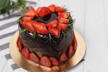 Yemek ve fırın konsepti için beyaz arka planda çilekli lezzetli çikolatalı pasta şeklinde bir kalp.