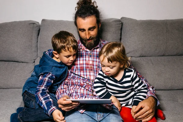 Ojciec Siedzi Kanapie Dziećmi Ogląda Filmy Tablecie Cyfrowym — Zdjęcie stockowe