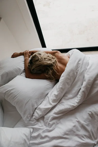 Sarışın Genç Kadın Yatakta Yatıyor — Stok fotoğraf