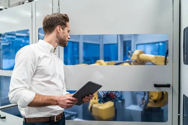 Empresário Com Tablet Olhando Robô Uma Fábrica Moderna — Fotografia de Stock