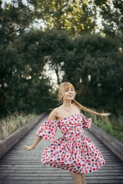 Tahta Kaldırımda Dans Eden Çiçekli Bir Elbiseyle Mutlu Genç Bir — Stok fotoğraf