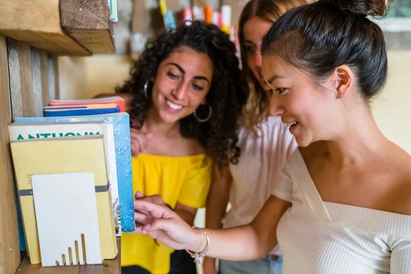 Drei Lächelnde Junge Frauen Bücherregal — Stockfoto