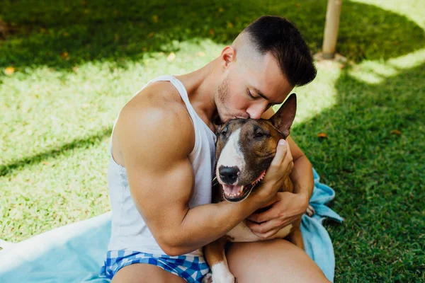 Muscular Man Sitting Blanket Meadow Hugging His Dog — Stock Photo, Image