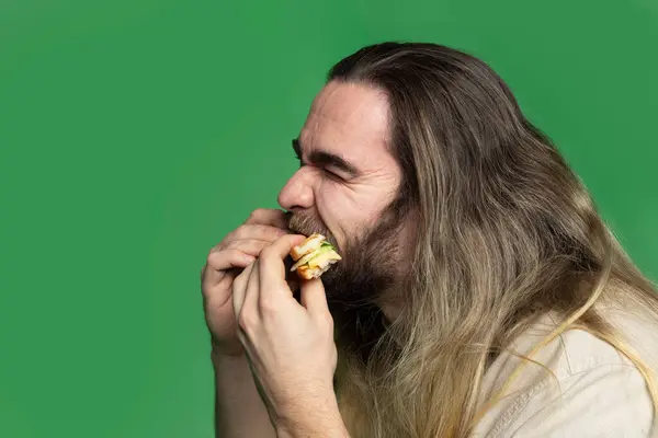 Uomo Barbuto Mangiare Panino Fronte Sfondo Verde — Foto Stock