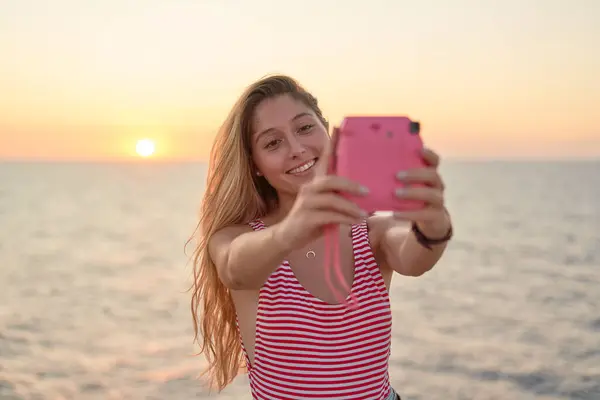 Ung Kvinna Tar Bilder Sig Själv Vid Solnedgången Vid Havet — Stockfoto