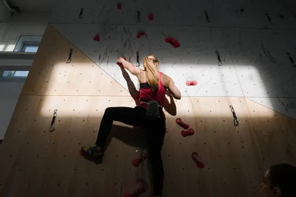 日光と影でジムに登る壁に登る女性 — ストック写真